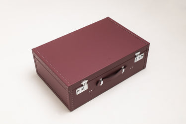 Handcrafted burgundy leather hard-shell suitcase with leather handle and polished metal hardware by Laurent Nay Maroquinerie