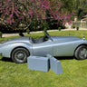 Jaguar XK140 Roadster with bespoke handcrafted leather luggage set displayed beside the car, custom-made in France by Laurent Nay Maroquinerie to fit the original trunk perfectly.