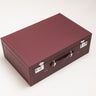 Handcrafted burgundy leather hard-shell suitcase with leather handle and polished metal hardware by Laurent Nay Maroquinerie