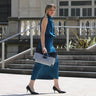 Woman carrying the Laurent Nay Léa handbag in black leather and black-and-white houndstooth fabric, handcrafted in France.