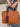 Burgundy leather glasses case attached to a handcrafted leather travel bag