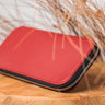 Closed Laurent Nay red leather travel wallet with zip-around closure and tartan lining, handcrafted in France.