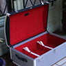 Open Signature decorative trunk showing its red fabric-lined interior, white retaining straps and blue and white houndstooth exterior.